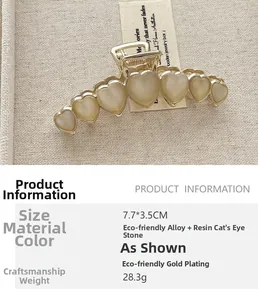 Détail macro de la pince à cheveux cœur dorée avec pierres œil-de-chat, taille 7,7x3,5 cm