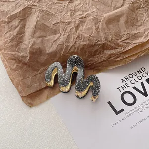 Macro detail of wavy glitter hair claw clip with golden metal teeth on vintage paper