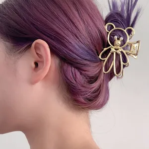 Elegante pinza de pelo de oso de metal dorado con perlas en cabello violeta