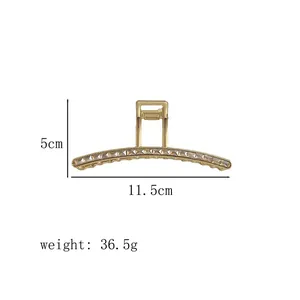 Detail view of 11.5cm golden metal hair claw with zircon accents and dimensions