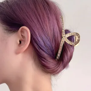 Golden alloy shark hair claw with zircon and pearl on model's long purple hair