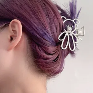 Elegante pinza de pelo de oso de metal plateado para mujer mostrada en un peinado