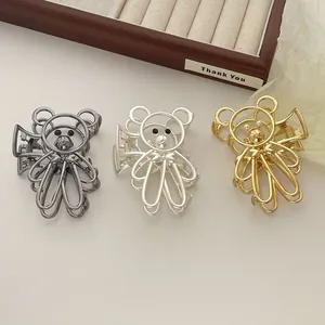 Primer plano detallado de tres pinzas de oso para el cabello en oro, plata y gris oscuro