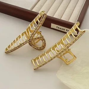 Close-up of golden metal hair claw clips with zircon rhinestones and hollow-out design