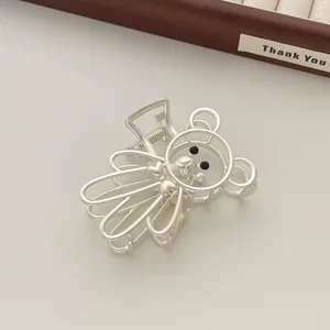 Detalle de la pinza para el pelo de oso plateado mate con corazón sobre bandeja de madera
