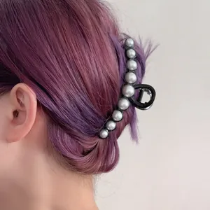 Eleganter schwarzer Haargreifer mit weißen Perlen für langes Haar in der Rückansicht