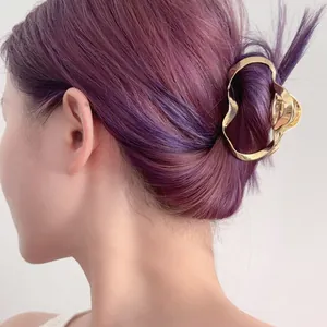 Pince à cheveux géométrique élégante en métal doré tenant un chignon violet