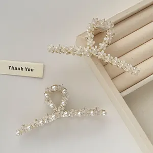 Eleganti fermagli per capelli dorati in stile coreano con fiori bianchi e perle su velluto