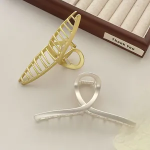 Detail van mat goud en zilver legering haarklemmen met een strak hol ontwerp