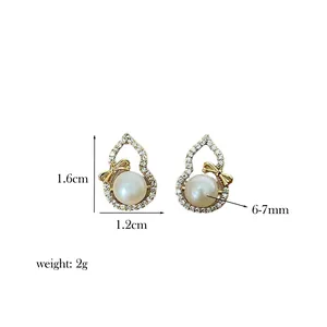Detailed size view of gourd-shaped pearl earrings with gold plating and bow detail