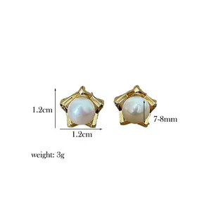 Macro shot of star-shaped gold pearl earrings measuring 1.2cm with 7-8mm pearls