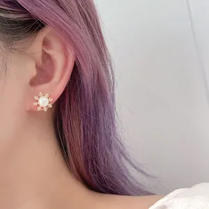 Macro view of snowflake pearl earrings on model showing elegant winter jewelry style