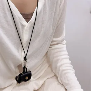 Close-up of a mini black leather earphone case with gold metal clasp and long neck strap