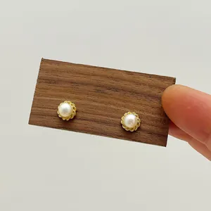 Detailed close-up of natural freshwater pearl earrings with golden petal base craftsmanship