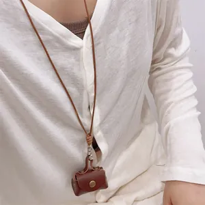 Mini brown leather coin purse necklace with adjustable strap for women on knit sweater