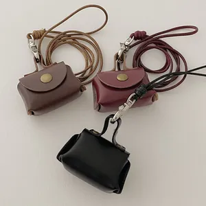 Mini leather coin purse necklace shown in brown, wine red, and black with long lanyards