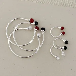 Detailed view of minimalist open bracelets and rings with pearl and agate beads