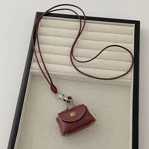 Detail view of mini burgundy leather coin purse necklace with bronze snap button