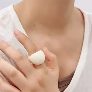 Close-up of minimalist cream resin dome ring on model hand with smooth glossy finish