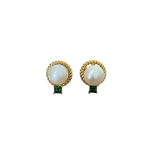 Elegant gold earrings with freshwater pearls and green gemstones on white background