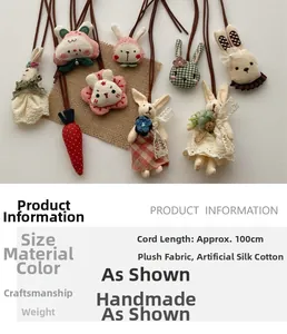 Detail of handmade rabbit plush charms showing lace dresses and fabric textures