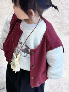 Detail of cute rabbit plush doll pendant on a child corduroy vest and bear print hoodie