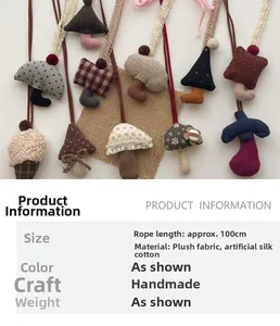 Detail showing handmade plush mushroom and tree charms with patterned fabric and lace cord