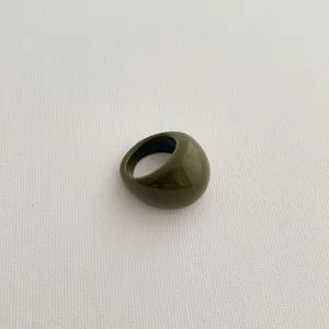 Close-up of olive green thick resin ring with polished finish and vintage style