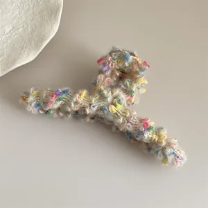 Primer plano de la pinza de pelo de felpa con lunares de colores e hilos de oro