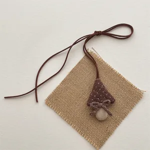 Detail of handmade mushroom plush pendant with brown fabric cap and corduroy stem