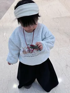 Detail of light grey kids sweatshirt featuring cartoon rabbit and puppy illustration