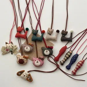 Detailed close-up of handmade cloth animal pendants with mini bells and polka dot patterns