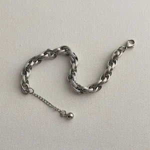 Makroaufnahme eines Silberarmbands mit spiralförmigen Ringgliedern und Karabinerverschluss