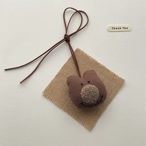 Handmade brown plush bear charm pendant with leather cord and rustic jute detail