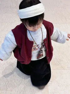 Detail of kids velvet vest and white sweatshirt with cute puppy illustrations