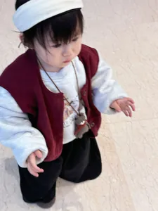 Detail of red vest with plush bear charm and matching toddler four-piece autumn outfit