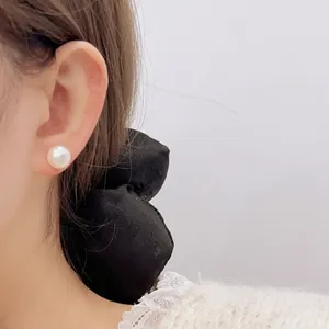 Elegante vergoldete Perlenohrstecker im Vintage-Stil, getragen an einem Frauenohr