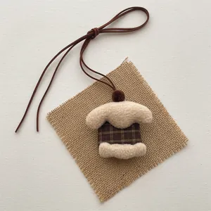 Detail of plush cartoon duck pendant featuring checkered fabric and soft lamb wool texture