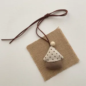 Handmade fabric tree pendant with polka dot corduroy and leather strap on burlap