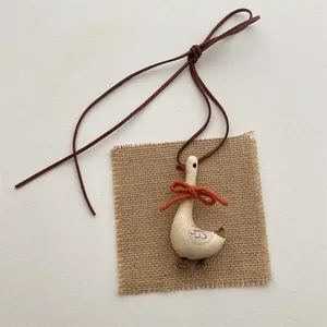 Detail of handmade cloth duck pendant with orange bow and rustic embroidery texture