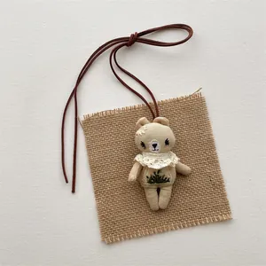 Handmade teddy bear plush pendant with forest embroidery and white lace collar decoration