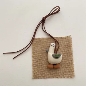 Handmade linen duck pendant necklace with rustic embroidery and brown leather cord