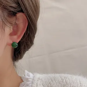 Elegante dunkelgrüne Achat Kugelohrstecker am Model für einen minimalistischen Luxus Look