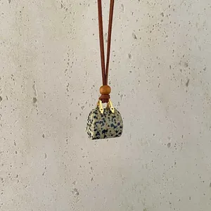 Macro shot of stone handbag pendant with leather cord and wooden bead detail