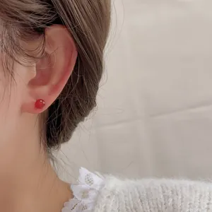 Elegante Ohrstecker mit roten Achatperlen am Model für einen minimalistischen Luxus-Look