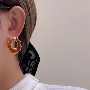 Vintage-Ohrstecker aus Bernsteinharz mit eleganten goldenen Metallrändern für Damen