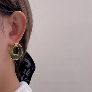 Elegante grüne Harz-Ohrringe im Retro-Stil mit goldenem Metallrahmen am Ohrläppchen