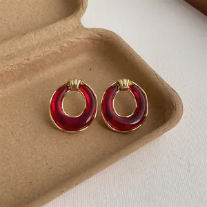 Detaillierte Makroansicht der Vintage-Resin-Ohrringe mit Goldrand auf Bastelpapierschale