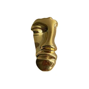 Vintage abstract gold face brooch with a high-polished metallic mirror finish