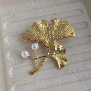 Élégante broche feuille de ginkgo dorée avec texture brossée et deux perles blanches